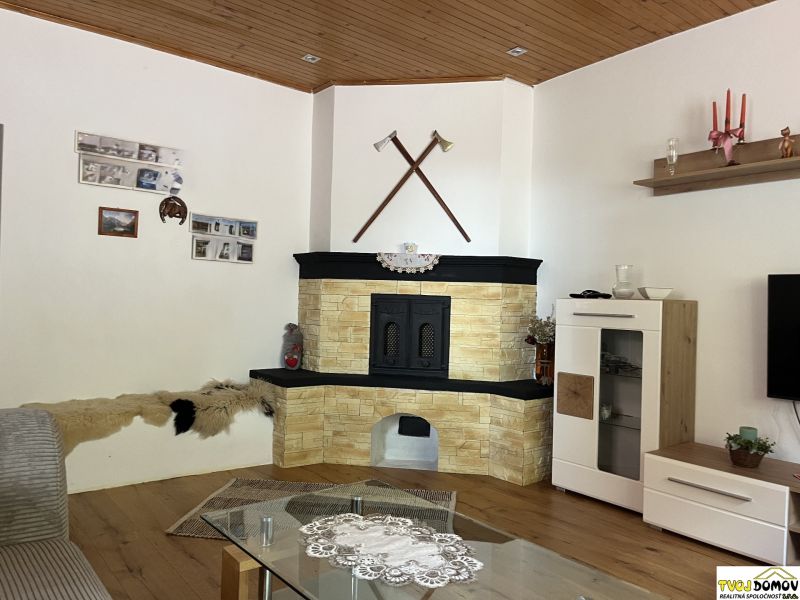 Interior of a family house with a tiled stove, wooden ceiling, and floor with a wooden decor.