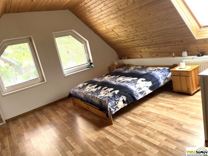 Bedroom in a family house with a bed and wooden decor flooring.