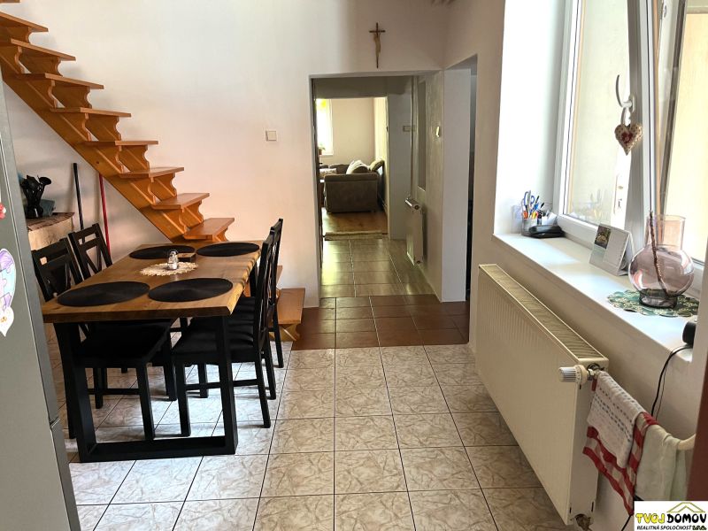 A kitchen in a family house with a dining table and a staircase.