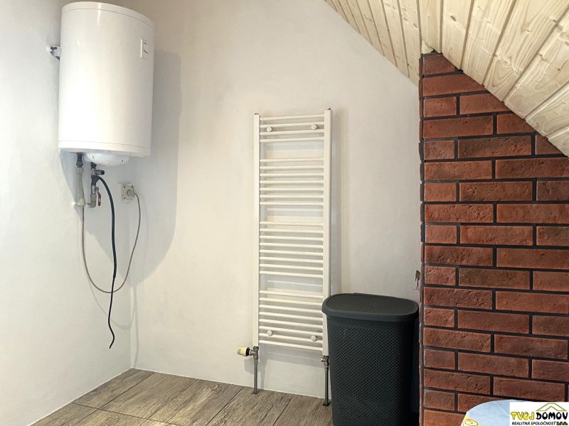 Boiler, radiator, and brick wall with wood-decorated flooring in a family house.