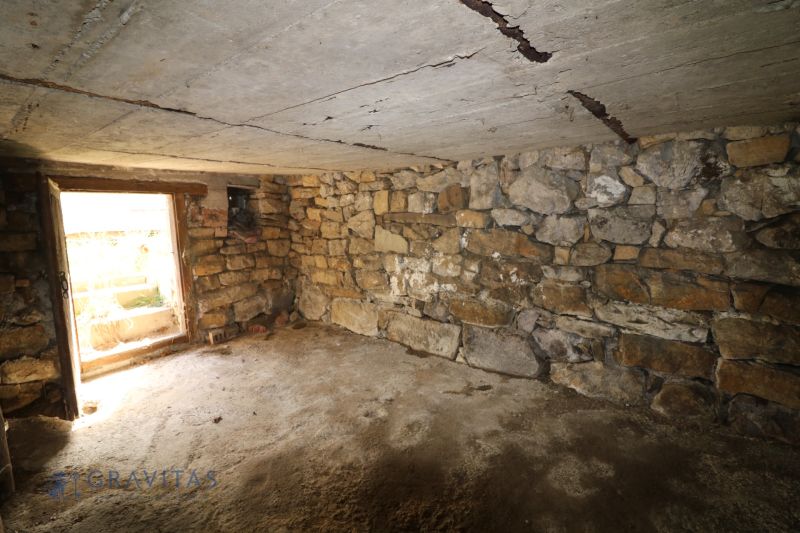 A stone cellar space in the construction phase of houses, showing raw walls and ceiling.