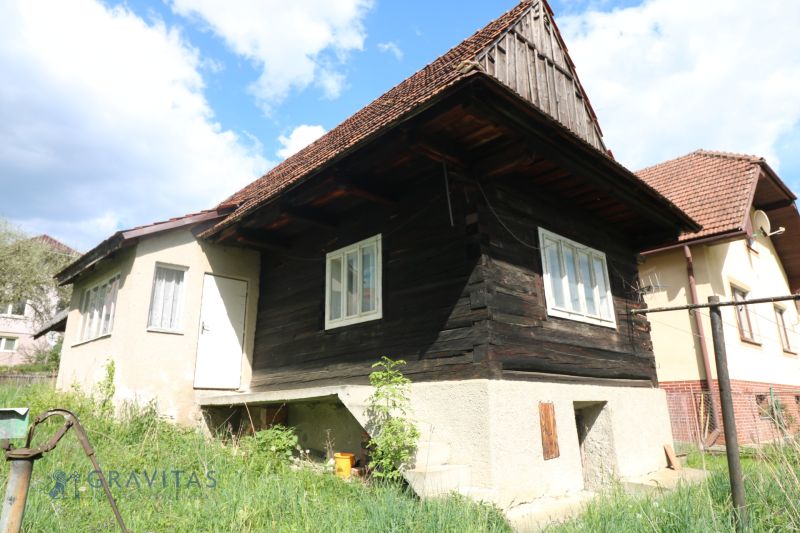 A log cabin with a concrete foundation on Matúšovská Street, Žaškov, surrounded by green grass. Construction of houses.