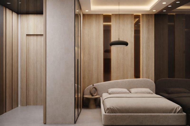 A bedroom in a studio apartment with a wood-patterned floor and minimalist furnishings.