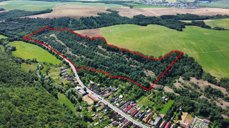 Aerial view of agricultural and forest lands in the village of Domaníky, outlined in red.