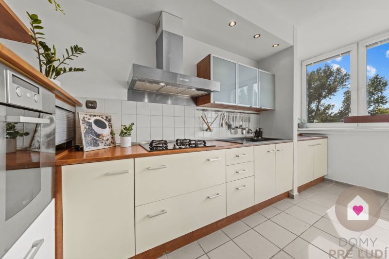 A kitchen in a 4-room apartment with white cabinets and built-in appliances.