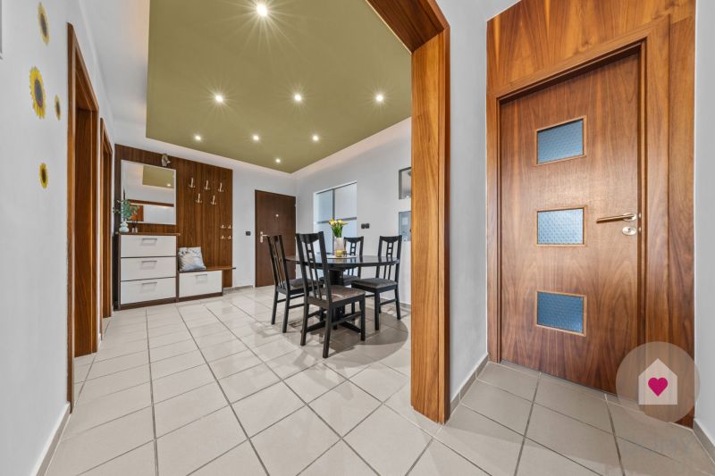 Dining room in a 4-room apartment with wooden doors and tiles, table with chairs.