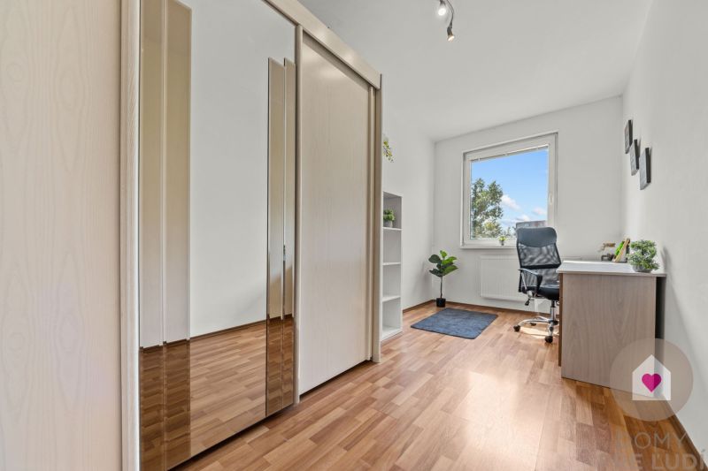 Home office with a desk, wardrobe, and wooden decor flooring.