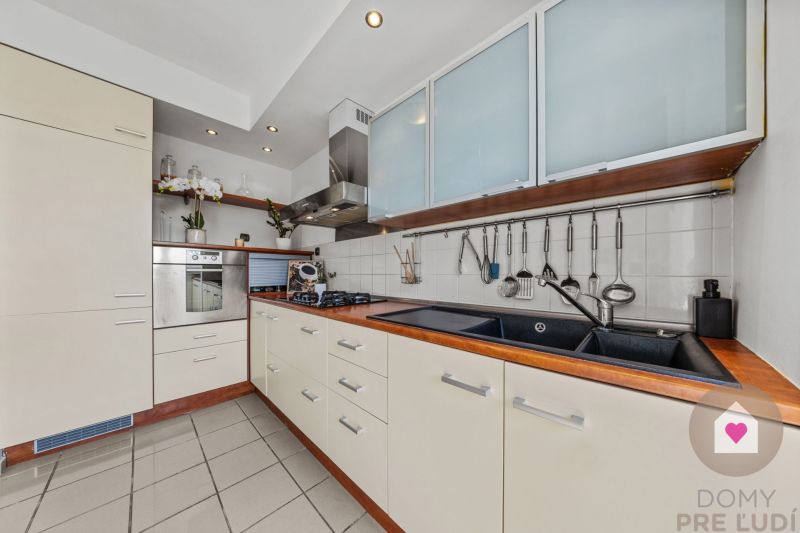 A kitchen in a 4-room apartment with kitchen cabinets, a sink, and built-in appliances.