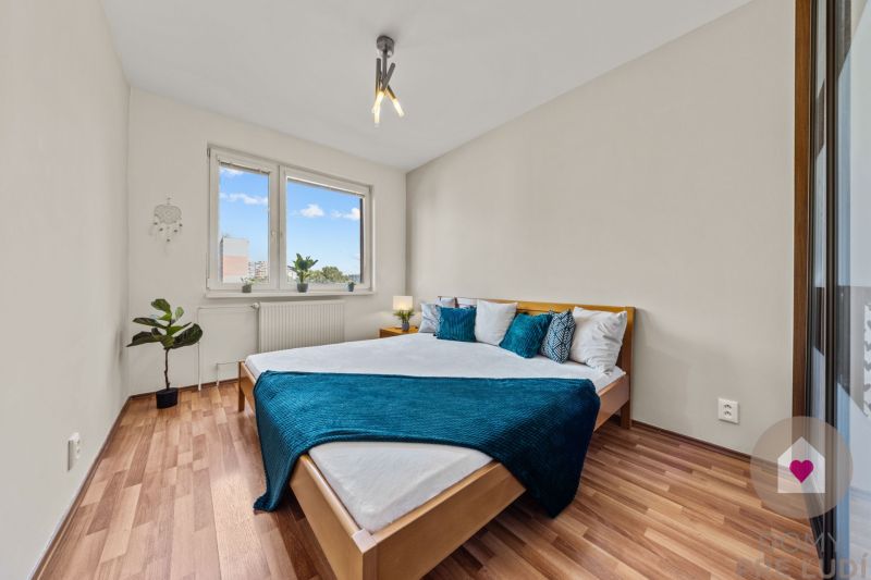 A bedroom with a wood-patterned floor and a bed in a 4-room apartment.