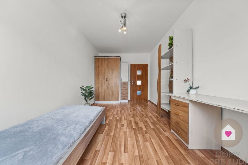 Bedroom in a 4-room apartment, bed, wardrobes, desk, floor with wooden decor.