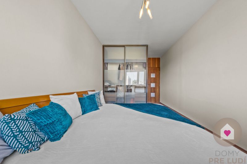 A bedroom in a 4-room apartment with decorative pillows and a built-in wardrobe.