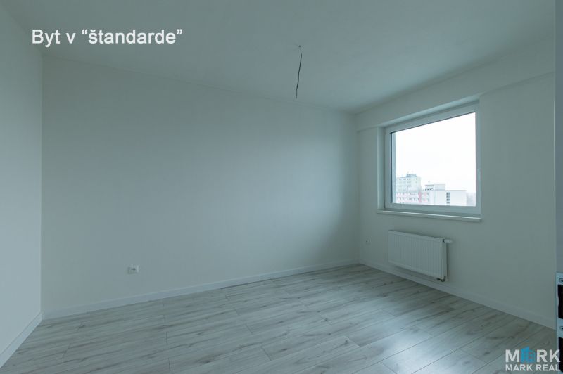 A room with a wooden floor decor, a window, and a radiator in a 2-room apartment.