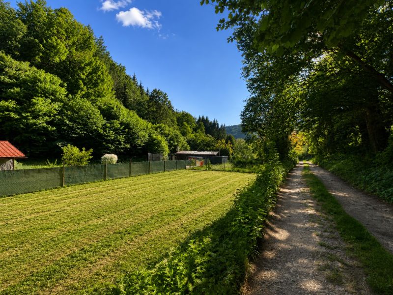 A plot for residential use in Kostiviarska, Banská Bystrica, next to Kostiviarska Road, surrounded by greenery.