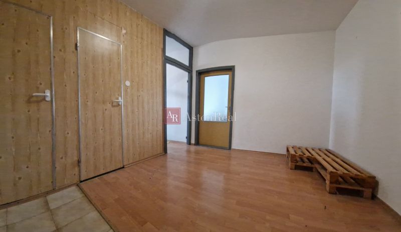 Interior of a 2-room apartment with wooden panel walls and a floor with a wood decor.