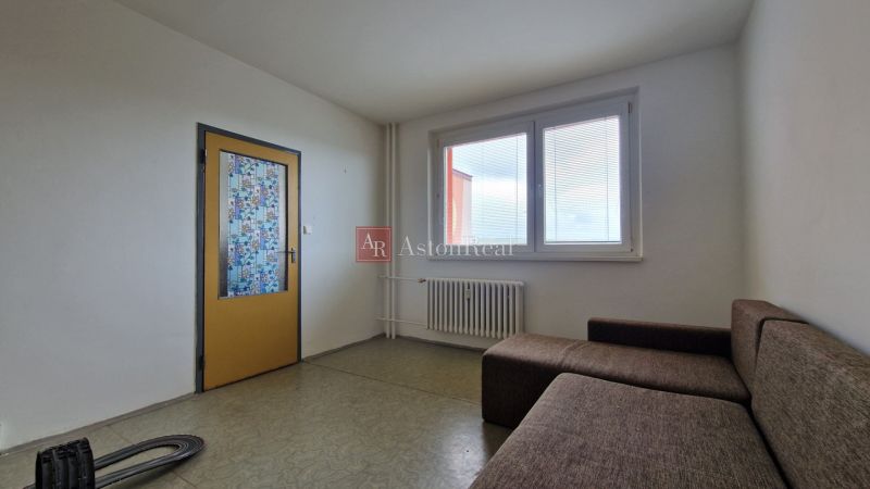 Living room with a brown sofa and mosaic doors in a two-room apartment.