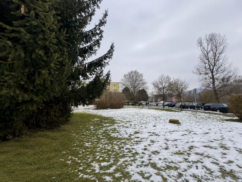 Snow-covered commercial lands in Zvolen with a view of the parking lot on Novozámocká.