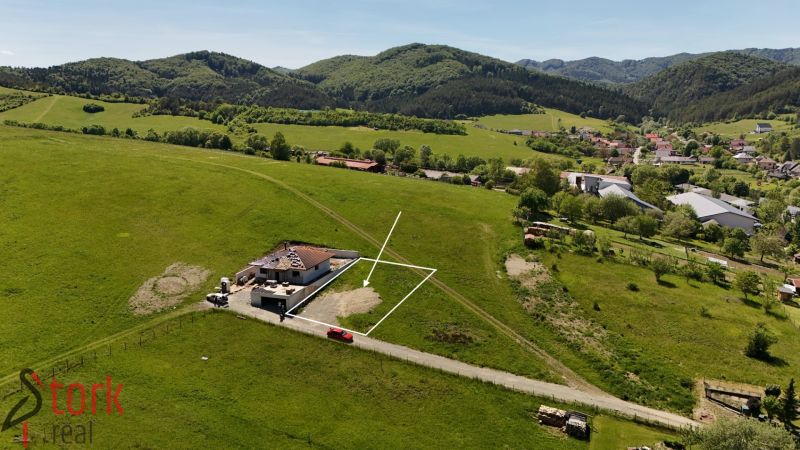 Residential plots in Lietavská Svinná-Babkov amidst green countryside with a village in the background.