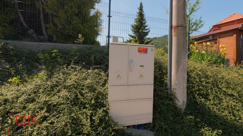 Electrical cabinet next to a pole and vegetation in Lietavská Svinná-Babkov, Residential plots.