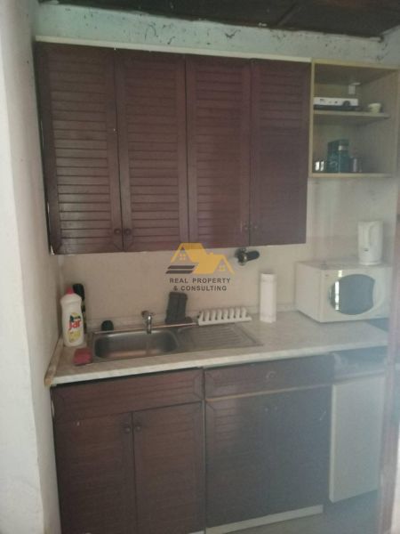 A kitchenette in a cabin with wooden cabinets and a sink, compact layout.