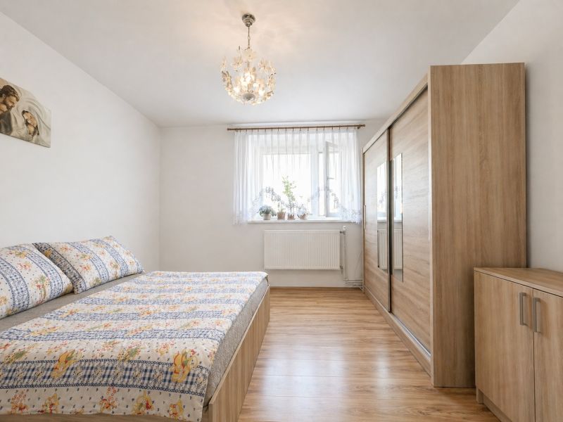 Bedroom in a family house with a wooden decor floor and a large wardrobe.
