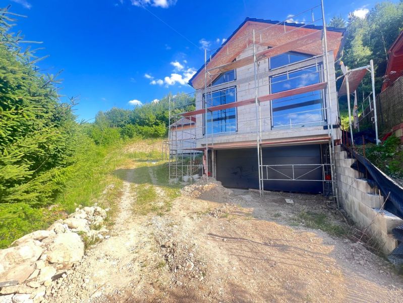 A family house under reconstruction with scaffolding, surrounded by nature in Badín, Banská Bystrica district, Slovakia.