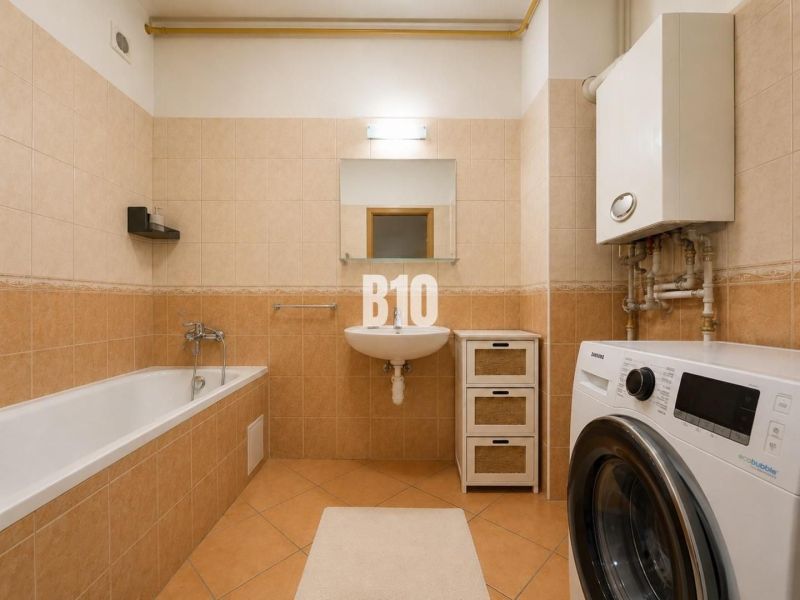 A bathroom in a 2-room apartment with a bathtub, washing machine, and gas boiler.