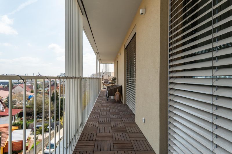 A balcony with a wooden decor floor in a 3-room apartment, view of Bratislava - Ružinov.