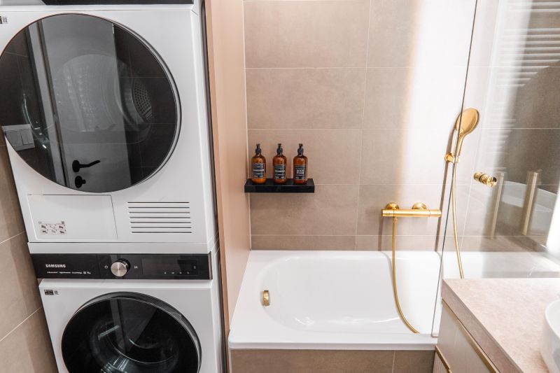 A bathroom in a three-room apartment with a bathtub, a washing machine, and decorative bottles on the shelf.