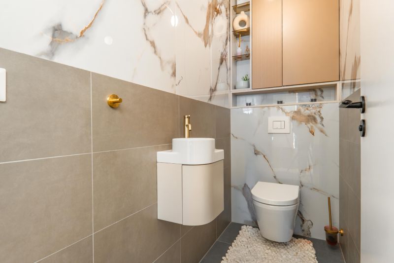 A bathroom in a 3-room apartment with a combination of ceramic tiles and gold accessories.