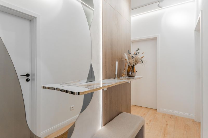 A hallway in a 3-room apartment with a minimalist table, mirror, and floor with a wooden decor.