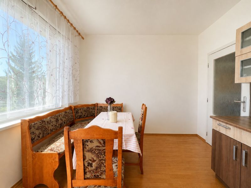 Dining area with a corner bench, table, chair, and floor with a wooden decor.