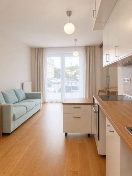 Living room in a two-room apartment with a wooden decor floor and a light-colored sofa.