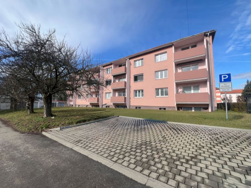 Apartment building with trees and parking on Dukelských hrdinov Street, Žiar nad Hronom.