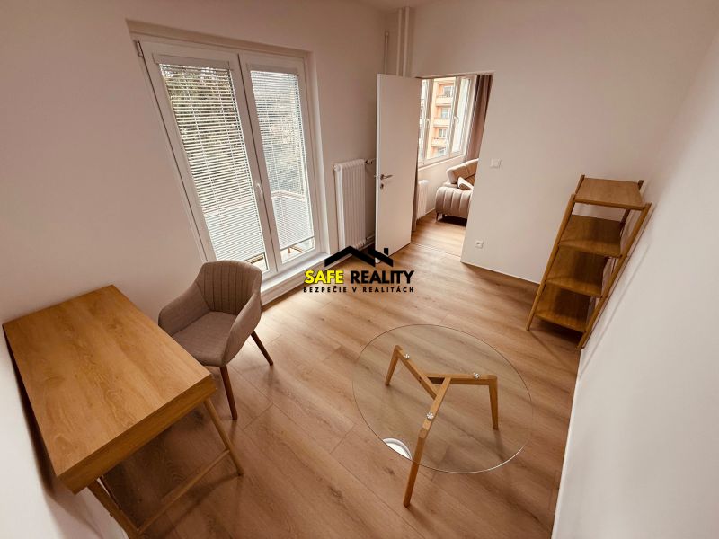 A room with a wooden floor decor in a 3-room apartment, a desk, a chair, a shelf.
