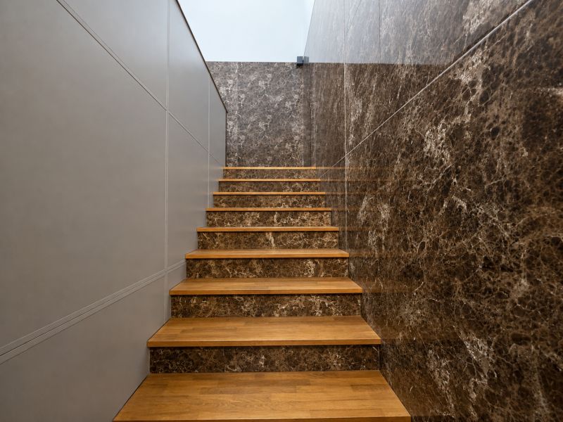 A staircase with a wood-patterned floor and marble walls in manufacturing premises.