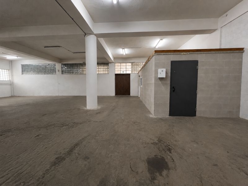Interiors of warehouses and halls with massive concrete columns and gray walls.