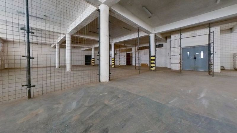 Industrial interior with columns and metal mesh in spaces for warehouses and halls.