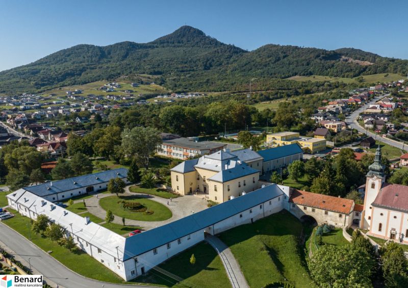 A historical building with a courtyard in the environment of Fintice, residential plots, surrounded by nature.