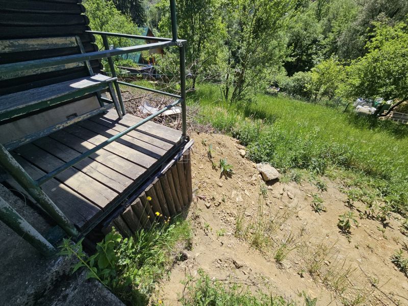 A cottage in Budatín with a terrace and a view of greenery and a slope.