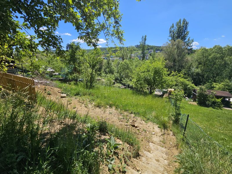 A sloped garden with a view in Budatín, Budatín, surrounded by lush greenery and a blue sky.