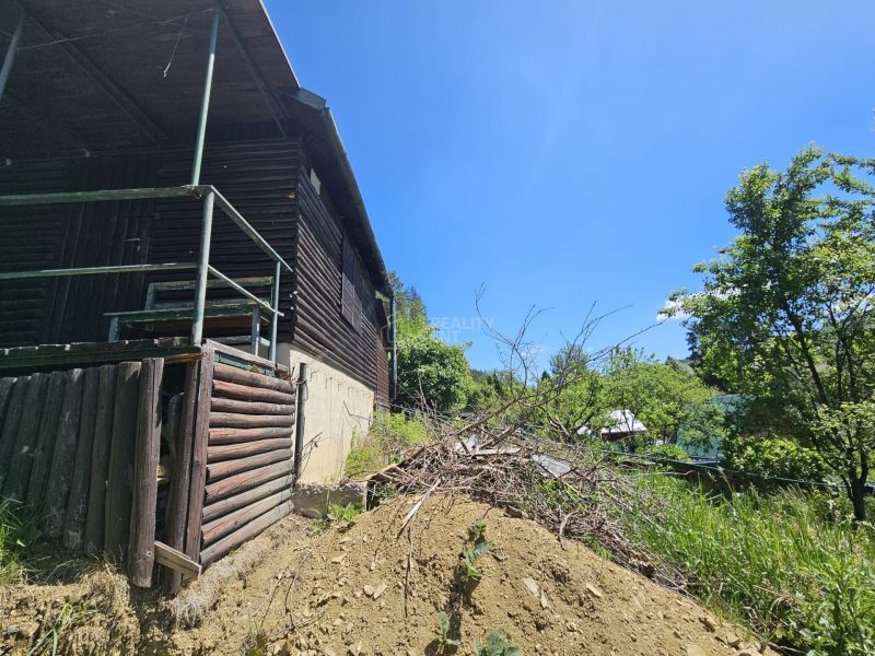 A cabin structure in Budatín surrounded by nature and greenery, wooden elements.