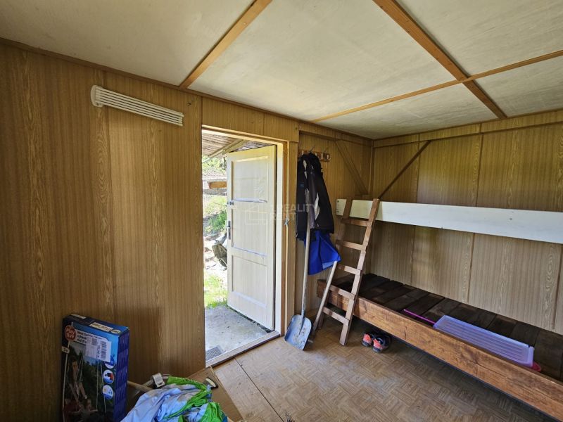 A room in a cottage with a bunk bed and a wooden decor floor.