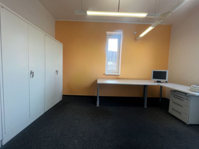 Office with furniture, computer, and cabinets on a light floor.