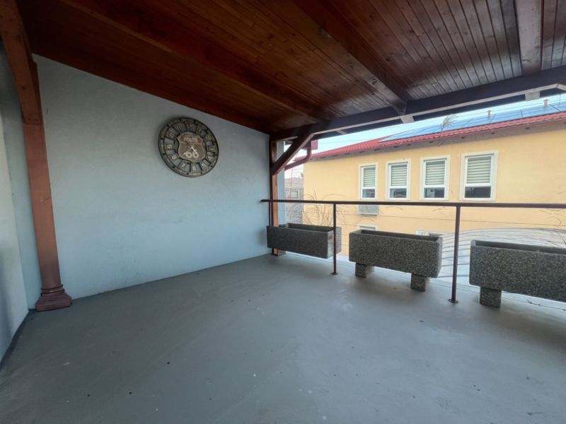 Covered terrace with clocks and flower pots in the production area.