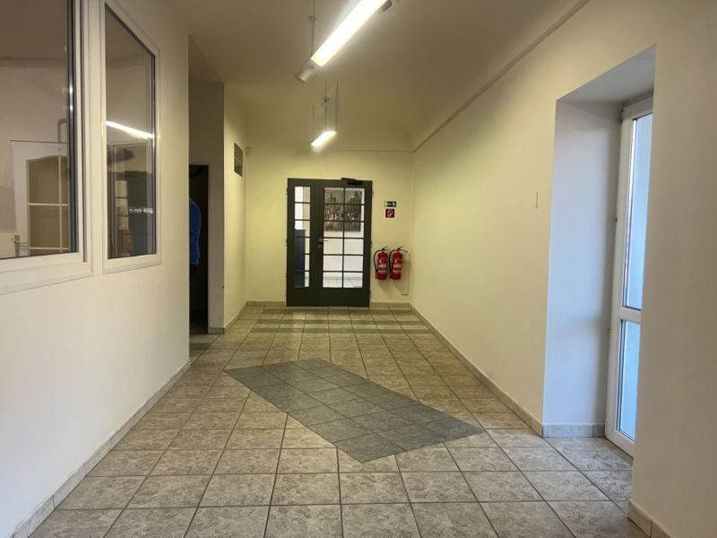 A corridor in production areas with ceramic tiles and double doors.