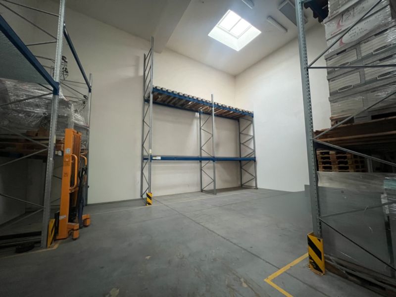 Warehouses and halls with high shelves and a skylight, concrete floor.