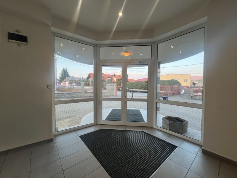 Glazed entrance door with a doormat and an outside view, production premises.