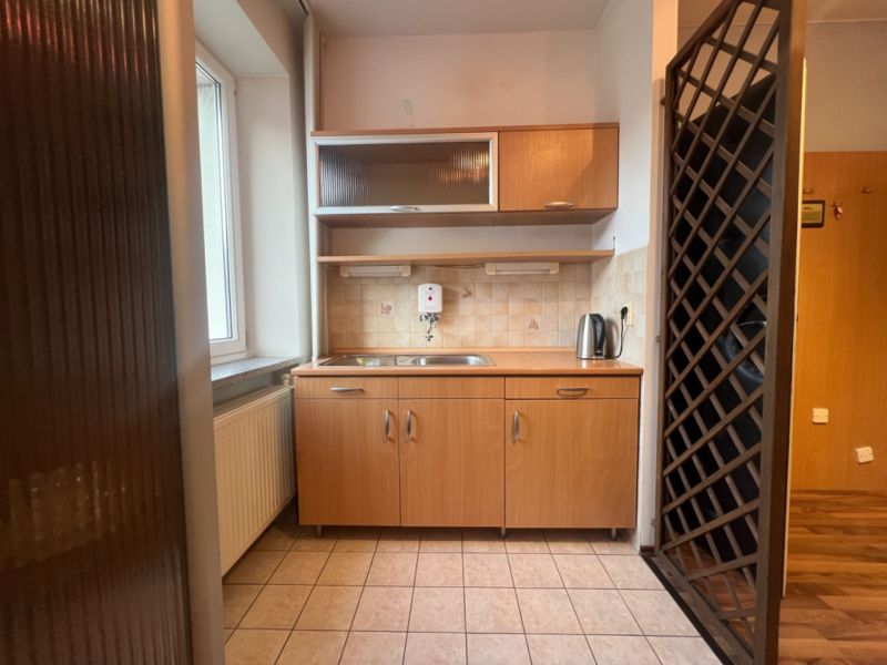 Kitchen unit with ceramic tile flooring and wooden decor in warehouses and halls.