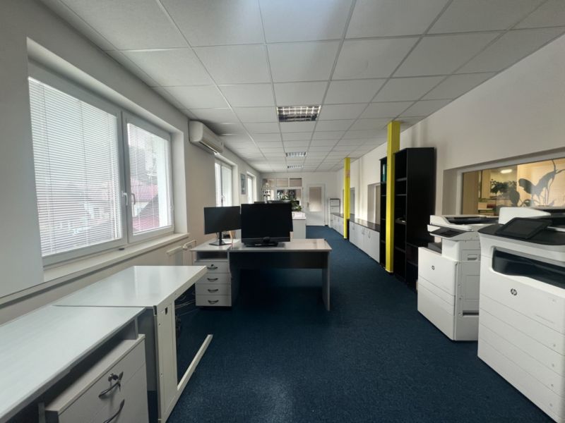 Office space with carpet, desks, monitors, and copiers.