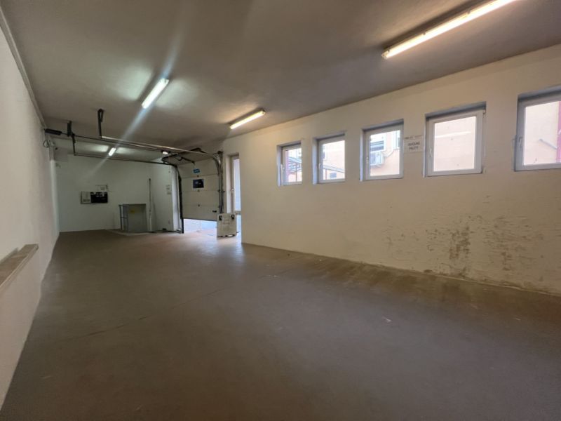 The interior space of warehouses and halls with windows and a garage door.